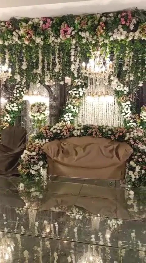 Greenery and blush florals reflected on a mirrored stage floor.